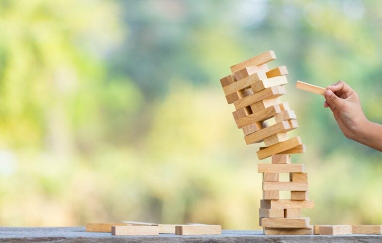 The jenga game ,tower stack from wooden blocks toy and hand take on block